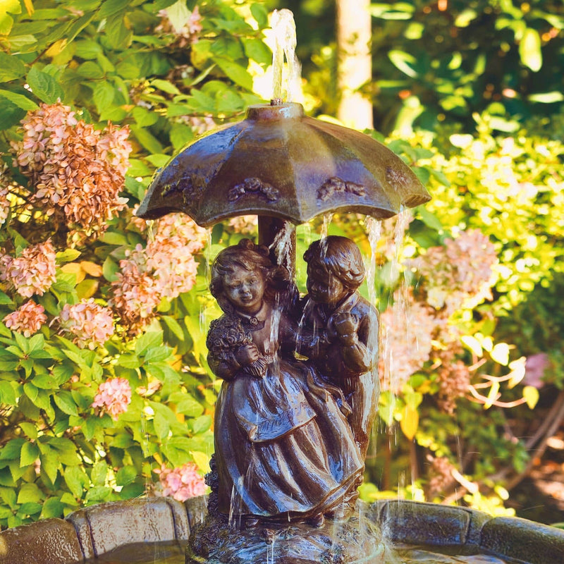 girl and boy under umbrella small concrete fountain massarellis fountains 3625